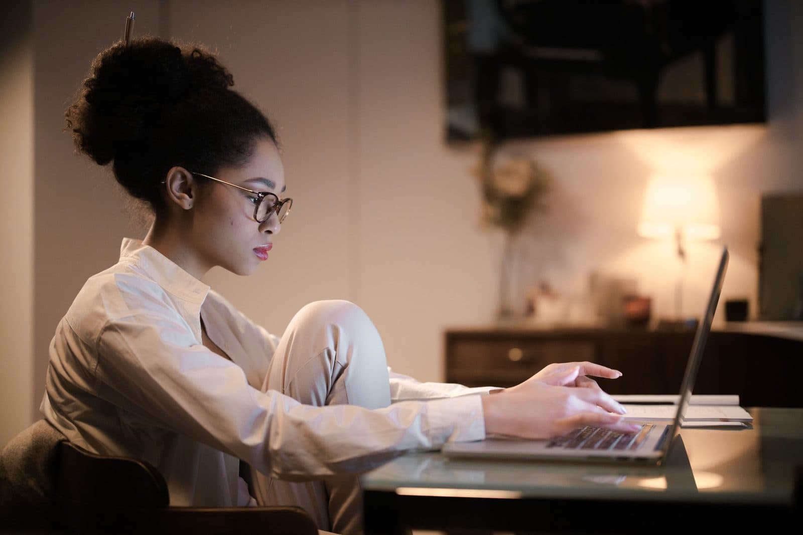 An implementer focused at a laptop in warm light
