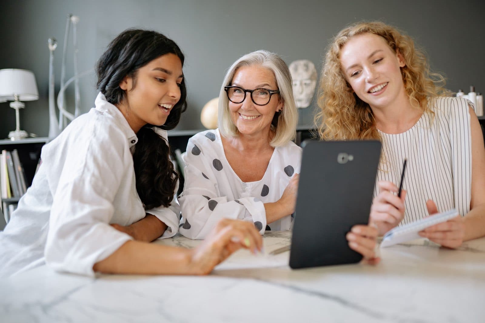 Business owners gathered around a tablet, comparing notes